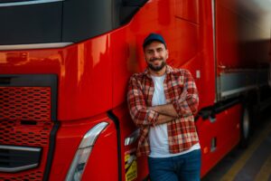 Vrachtwagen chauffeur staat trots naast zijn vrachtwachten - Geslaagd voor zijn Code95 cursus bij Westpoort - Opleidingscentrum Westpoort