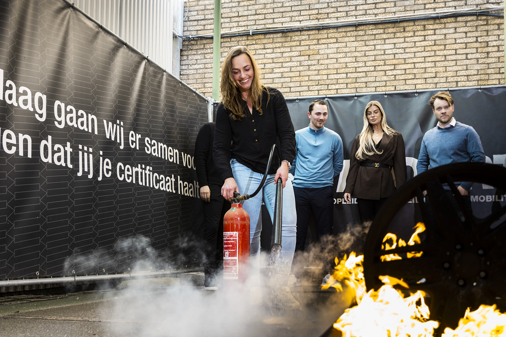 BHV-cursist oefent met een brandblusser tijdens een praktijkgerichte BHV training bij Westpoort.